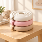 Coiled soft foam edge bumper strips stacked in white, pink and beige tones