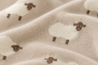 Close up of soft knit texture and sheep pattern stitching on baby blanket