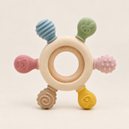 Wooden ring silicone teether toy with pastel animal shapes on a neutral background